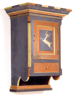Hanging wall cupboard attributed to Jacob Spitler (1774–1837), Shenandoah, now Page, County, Va., circa 1800–01. Yellow pine, brass hinges, replaced brass knobs, original painted decoration, overall 35 by 18½ by 12 inches. This is the first recorded example of a hanging wall cupboard with decoration attributed to Johannes Spitler. A Spitler decorated tall clock is in the collection of Colonial Williamsburg. Spitler furniture was unknown to scholars prior to the early 1970s. This cupboard was discovered in August 2004 and subsequently sold by Green Valley Auctions of Mount Crawford, Va., in 2004.