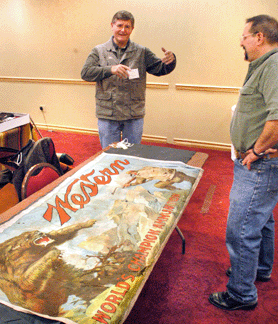 Ken Waite shows his rare Western banner to a prospective customer.