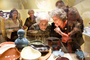 Eva Zeisel and her daughter, Jean Richards, peer into a display case.