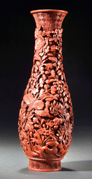 Cinnabar pyriform vase, China, Qianlong period (1736–1796), height 6½ inches. The design is a deeply caved floral motif. The function of this vase, judging from its size and shape, is to hold incense implements: a spade, which is used to flatten the sand in the censer; and a pair of narrow silver or bronze sticks connected by a short chain, used to pick up the incense pellet to place it on the sand in the censer. Vases for holding these implements are often placed on the scholar's table, as evidenced by their depiction in paintings of scholars' studios.