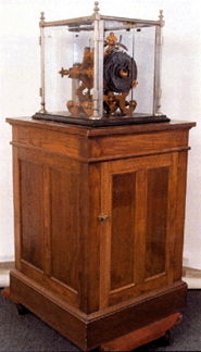 Gamewell four-station transmitter in glass case, weight driven, complete with key, slate base, mounted on an oak cabinet measuring 31 by 33 by 46 inches, sold for $12,210.