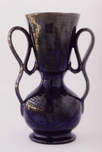 A fancy vase with wonderful freeform strap handles in a dark gunmetal glaze Collection of The OhrOKeefe Museum of Art Biloxi Miss
