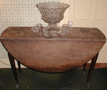 Atop the walnut swing leg table 9900 was a Heisey punch bowl that reached 220