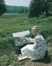 Grandma Moses painting in a field Copyright Grandma Moses Properties