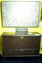 A 1750s Massachusetts pine blanket chest was topped with a wild goose chase pattern crib quilt in the booth of Janice F Strauss American Antiques