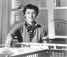 Knoll Bassett is pictured with a model for a project Behind her is the skeleton of a skyscraper in progress
