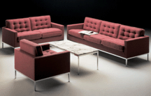A settee a sofa and a lounge chair from the Executive Collection of 1961 are upholstered in a handsome mulberry color The coffee table is of Knoll Bassetts parallel bars design
