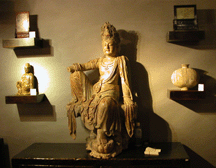 At KoKo of New York City this large wooden figure of a Guanyin goddess of mercy from the Ming Dynasty was echoed by a smaller version at left from the Eighteenth to Nineteenth Century