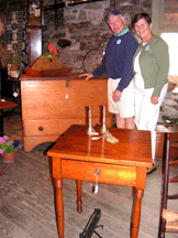 Princeton NJ dealers Helen and Larry Bryan HampL Antiques are standing in front of a mule chest
