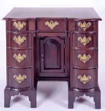 A 1745 Boston mahogany bureau table or kneehole desk demonstrates the more reserved form of pieces made in Massachusetts at the time