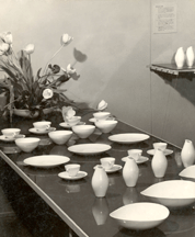 The installation of the Museum Service line at the Museum of Modern Art in 1946 took into consideration how pieces would look in the dim lighting of a formal table one display showed objects in diagonal rows on a reflective table surface Photograph courtesy of the Eva Zeisel Archives Walter Civardi photo
