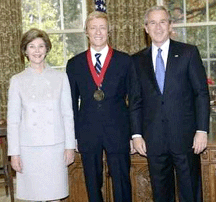 Leslie Leno stands with the President and Mrs Bush after receiving his award