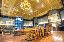 Entering the main reading room one sees bronze Carrre and Hastings chandeliers that shed light and reglazed windows capture outside light The 20foothigh plaster ceiling is matched to the original color palette of green and vermillion with Dutch metal and copper leaf accents and finished with sculptural details of fruit and vegetable forms seashells dragons and cherubs The tables are fitted with flat screen computers