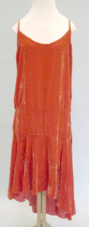 Red velvet evening dress late 1920s This bias cut longwaisted dress has an uneven hemline popular in the 1920s for a more carefree asymmetrical look
