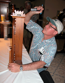 Rick Merritt of R Merritt Inc Reading Penn looking closely at lot 211 an American 27 14inchhigh EN Welch Arditi walnut eightday clock It went for the high estimate of 1200