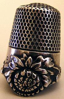 This Ketcham & McDougall dropped rim chrysanthemum thimble sold for $1,025 despite a hole in the top.