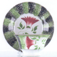 A green and black rainbow spatter cup and saucer with red thistle decoration tied for the top lot at 23000