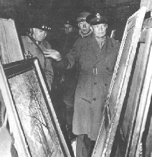 Allied Commander General Dwight Eisenhower examines Nazilooted paintings found in a salt mine Standing behind Eisenhower is General George Patton who had resisted the MFAampA