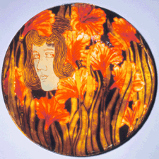 Art Nouveau floral themes were interpreted in various innovative ways by Zsolnay artists Here a wall plate designed by Henrik Darilek 18991900 shows a female head peering from a forest of fire lilies