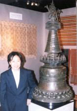Vicki Shiba of Vicki Shiba Mill Valley Calif stands next to a Twelfth Century bronze stupa from central Tibet shown in her booth