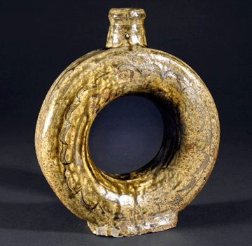 The ring jug with an alkaline glaze was made at the Summit Pottery in Blount County, circa 1880. Such vessels, also called "harvest jugs,” may have been designed to be tied to a saddle or harness. Its design origins are unknown.