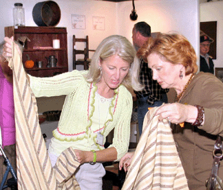 Inspecting a textile at Esther Caswell/Cindy Woods, Canton, Ohio.
