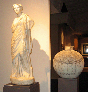 Among the classical and Byzantine works shown by Phoenix Ancient Art, Geneva, Switzerland and New York City, was this Roman goddess, First⁓econd Century AD, $350,000, and at right a Daunian terra cotta askos, Third Century BC, $35,000.
