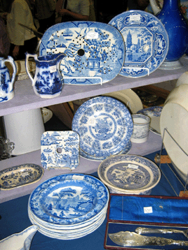 Lionel and Jacqueline Hill, now make Lehigh Acres, Fla., their home, but originally came from Wales. In a booth well-stocked with blue and white transfer-printed Staffordshire, there was a stack of Wild Rose soup plates, a Christ Church Oxford dinner plate for $80, and the Blue Willow drainer at top center was $275.