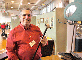 Steve Fisch, Wappingers Falls, N.Y., had an eclectic booth. Everything from a folk art Vietnam-era "Huey†helicopter weathervane, partially seen above right, to the Nineteenth Century birding cane he is holding could be acquired by the discriminating collector.