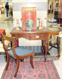 J. Gallagher, Norwich, N.Y., is known for its antique hearth fixtures, but also showed this general store tea canister, circa 1870, grouped with a walnut legislature desk, circa 1830, and a mahogany classical chair from the same period.