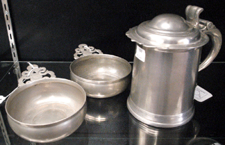 An Eighteenth Century lidded tankard by New York pewterer Joseph Leddel sold at $60,320. The John Bassett porringer, left, sold at $15,240, and the Frederick Bassett porringer brought $6,030.