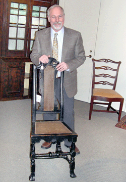 Stephen L. Fletcher is pictured with the superb circa 1715‱725 Boston maple and caned crooked back side chair that brought an impressive $110,500. The chair is one of three known examples.