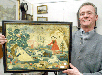 Auctioneer Ed Nadeau with the rare crewel embroidered Fishing Lady school canvas work picture that sold to Old Saybrook, Conn., needlework specialists Stephen and Carol Huber for $86,250.