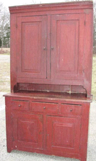 A two-part country cupboard in old red paint sold to an Internet buyer for $3,450.