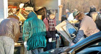 Buyers rushed the vendor, center, as he tried to unload, scrutinizing art and old instruments as they came out of the truck. 