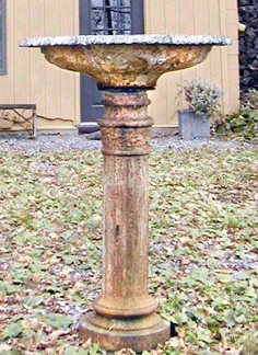 The stolen and found birdbath comprises a hexagonal cast iron fountain with embossed decorative detail married to a bottom piece consisting of a tall cast iron fluted pedestal base.