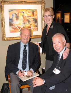 Marcy Burns, center, and Richard Schillay, right, of Schillay Fine Art, Inc, New York City, catch up with a collector. Upper left is the Jean Dufy watercolor "Workers on The Seine†of circa 1935.