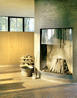 Critics may have called the Glass House "cold,†but how could any house that boasts a roaring fire not be bathed in warmth and ambience? Johnson placed the fireplace in one part of the brick tower. The back half contains the bathroom.