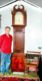 Harry W. Hepburn III, Hermitage Antiques, Harrison, Maine, with his tall case clock, "taller by half†than himself.
