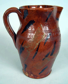 Fine and highly decorated redware pitcher attributed to the Cain pottery family of Sullivan County, Tenn., that sold for $22,550. 