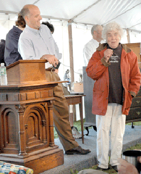 Bill Smith leans on the podium before the sale as Libby Backofen says a few words to the crowd attending her sale.