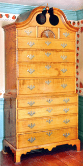This fine Chippendale chest-on-chest in curly maple, bonnet top with conforming drawers, fan carving on upper central drawer, original brass, sold for $44,000. It measures 82 inches high, is of New Hampshire origin, and dates circa 1750.
