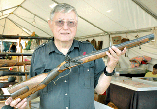 Livio Cillo holds a rare small carbine that saw action during the Revolutionary War when a scout for Anthony Wayne's infantry carried it. It has the original flintlock and is of German-type design, said the Merrimack, N.H., dealer. ⁆axon's Midway