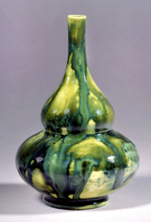 An unusual pottery vase, circa 1904, in various shades of green over a light yellow glazed body. Marked with the "LCT†monogram.