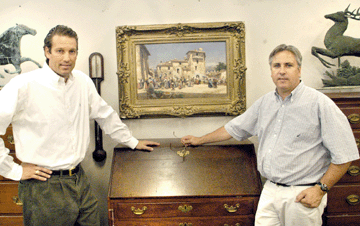 Jay Williamson, left, assisted auctioneer John McInnis, right, with the vast selection of artwork offered in the sale. The Mariano Barbason oil on canvas depicting performers in a European town square, fresh from a home, sold for $184,000.
