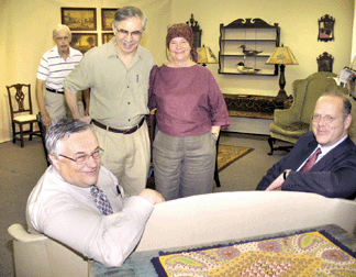 Dinah and Stephen Lefkowitz consulted Massachusetts dealers Elliott and Grace Snyder, center, when building their collection. Left, auctioneer Ron Bourgeault and right, James French, consultant to Northeast Auction. Rear left, four paintings on panel of the four seasons ($35/50,000) passed. Rear right, whale's tail hanging shelf, $10,400; merganser hen stamped G.R. Huey, Maine, $11,020; merganser drake by Captain Samuel Collins, Essex, Conn., $13,930. In the foreground, a felt penny rug that brought $3,460.