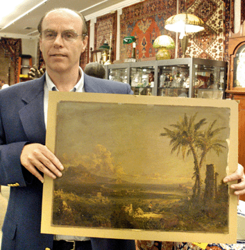Auctioneer Robert Foster with a painting on paper laid on canvas by Jasper Cropsey that had been discovered in a local barn. Relegated to a junk pile and covered with stuff, the painting was dusted off by the auctioneer and sold for $143,000.
