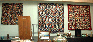 Quilts were front and center during the auction, positioned behind the podium. From left were the crazy quilt that brought $626, the Tumbling Blocks quilt at $1,150 and a fan quilt at $225.