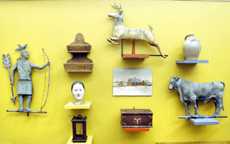 The Indian weathervane sold for $6,612, the wall box $1,437, the milliner's head $575, the stag weathervane $7,475, the country farmhouse scene $690, the incised stoneware jug $1,380, and the bull weathervane realized $5,750.