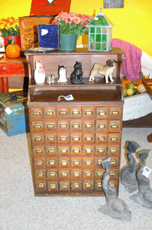 The Brewster Shop of Cape Cod had a circa 1860 French bistro chest with numbered drawers that held the flatware and napkins of "special†customers to the Paris restaurant. The three lead dolphin garden ornaments are English.